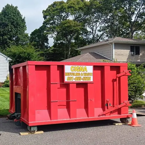 Branded Cigna Recycling and Waste roll-off dumpster at a Long Island home