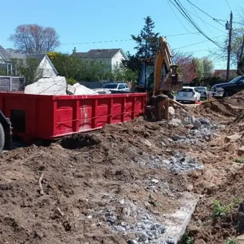 Red Cigna dumpster beside an active excavation project